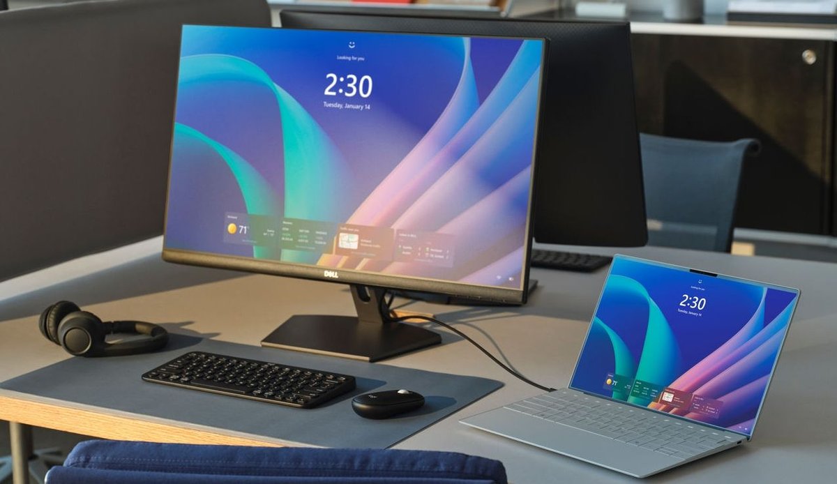 Windows 11 desktop PC and laptop on a desk, the kind of machines point-in-time restore protects