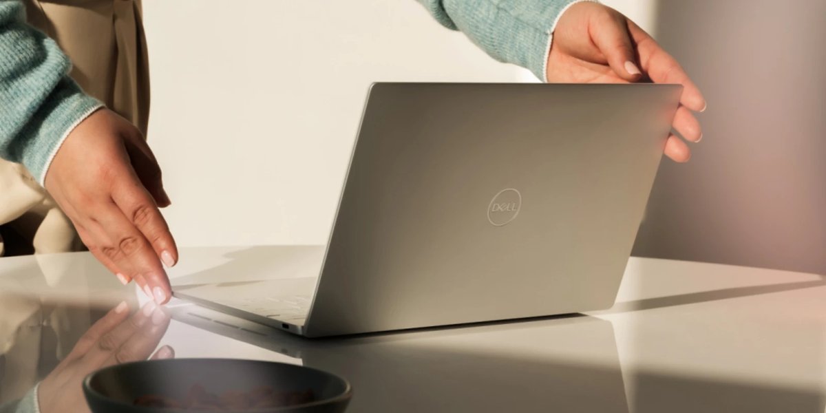 A person opening a Windows 11 laptop on a desk, illustrating the Memory Integrity security change coming in October